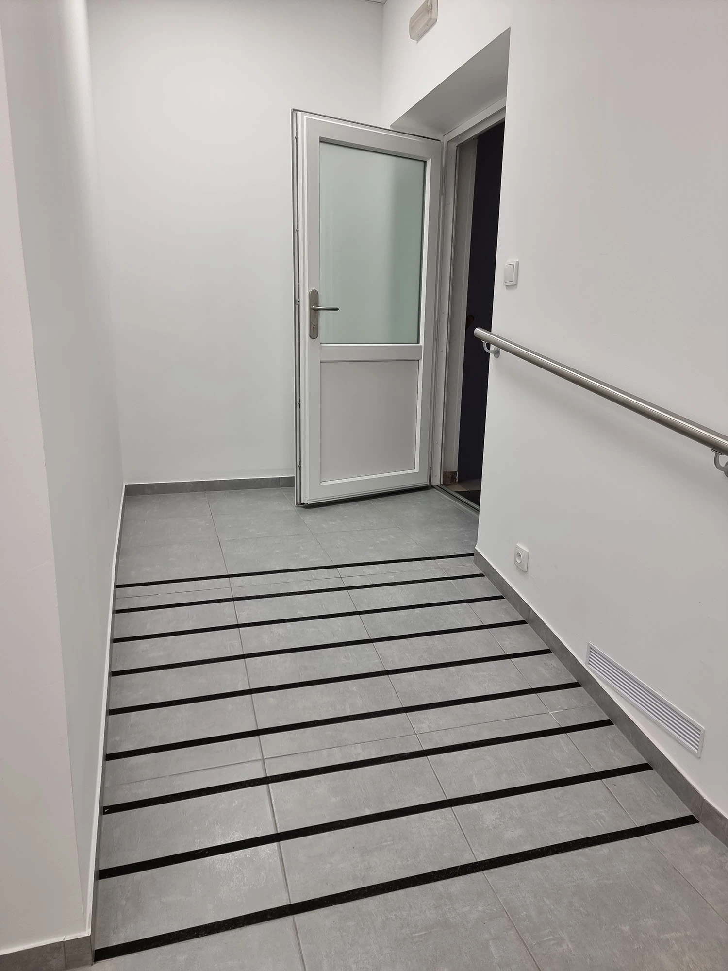 Bezbariérový vstup do ambulance s rampou, madlem a prosklenými dveřmi